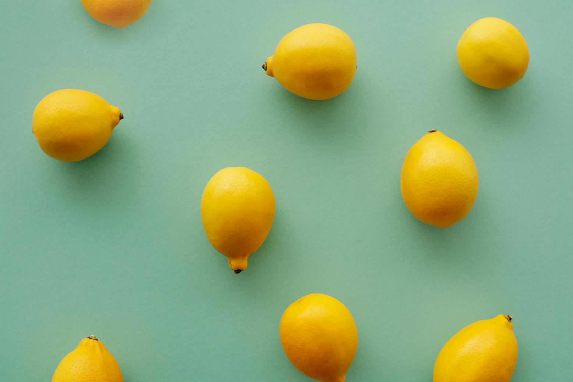 Fresh yellow lemons stacked with books on a white surface, symbolizing the layered support needed for pelvic health