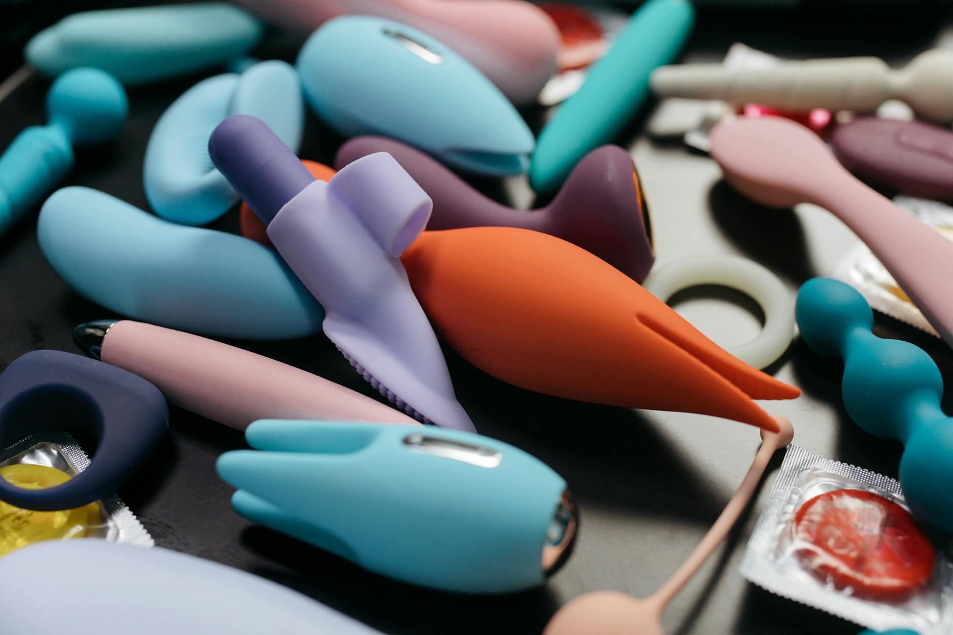 A young couple standing together indoors, holding a blue vibrator, symbolizing modern intimacy.
