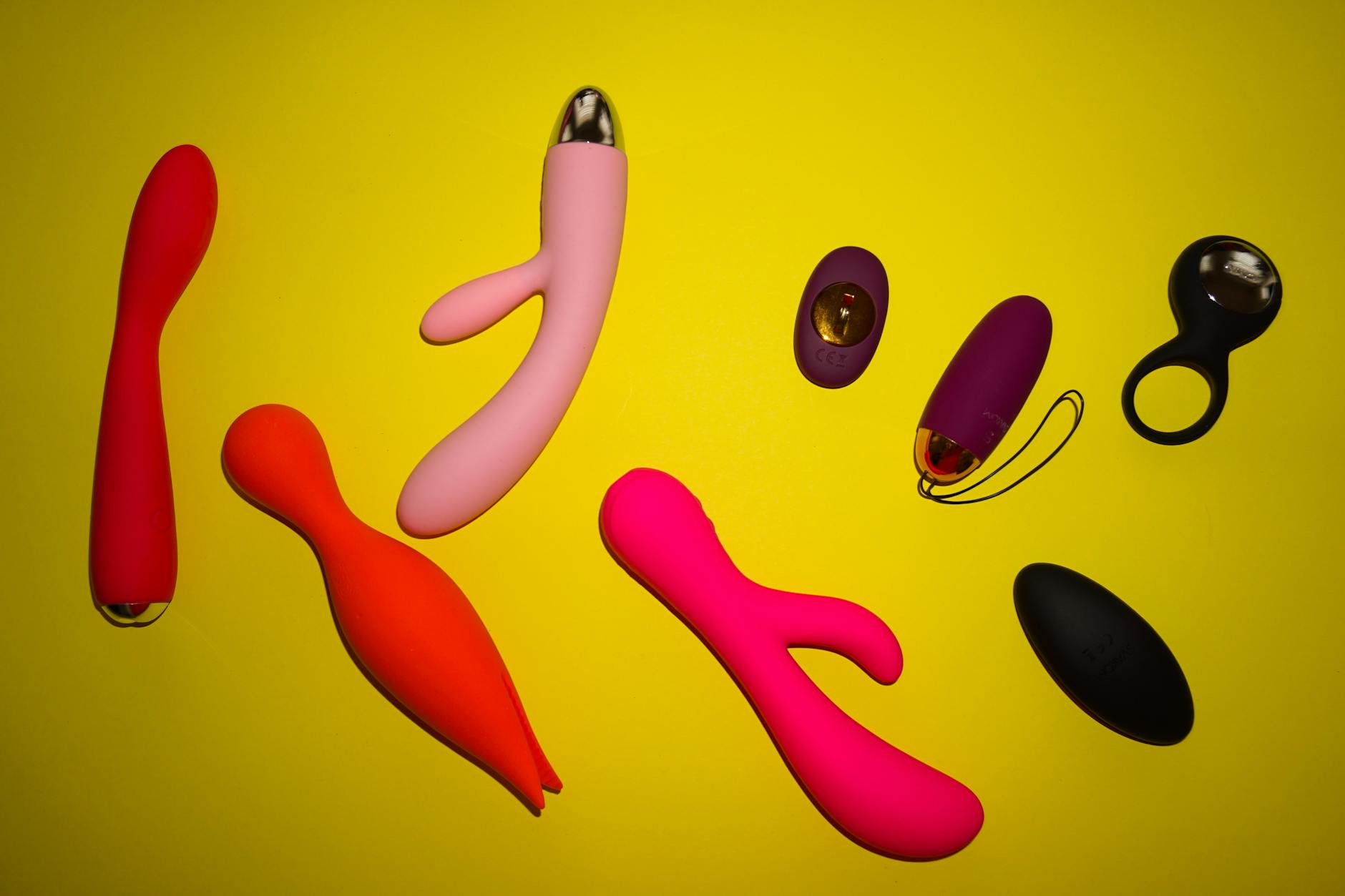 Close-up of colorful vibrators and adult toys arranged on a black surface