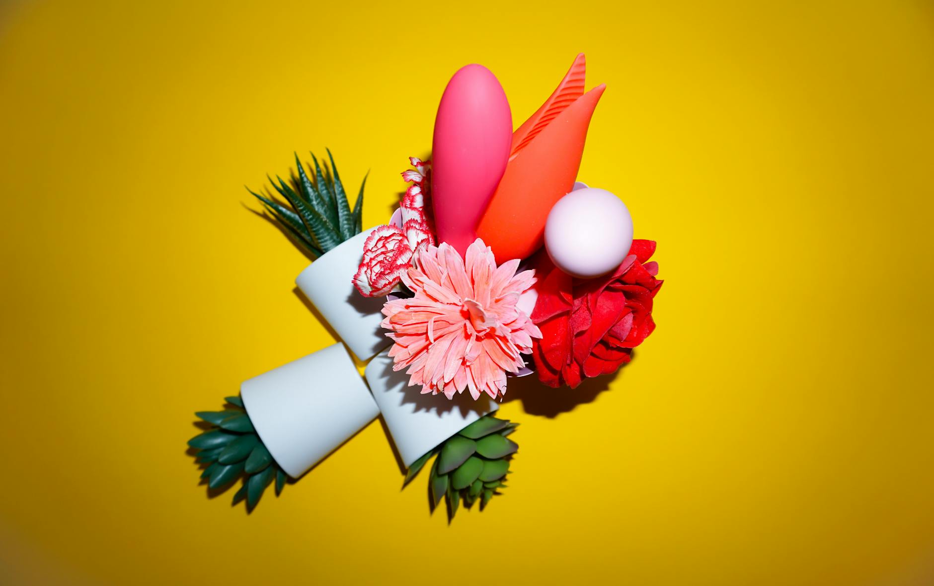 A hand with white nails holding a lemon on a soft pink background, representing the fresh, intentional approach to pleasure