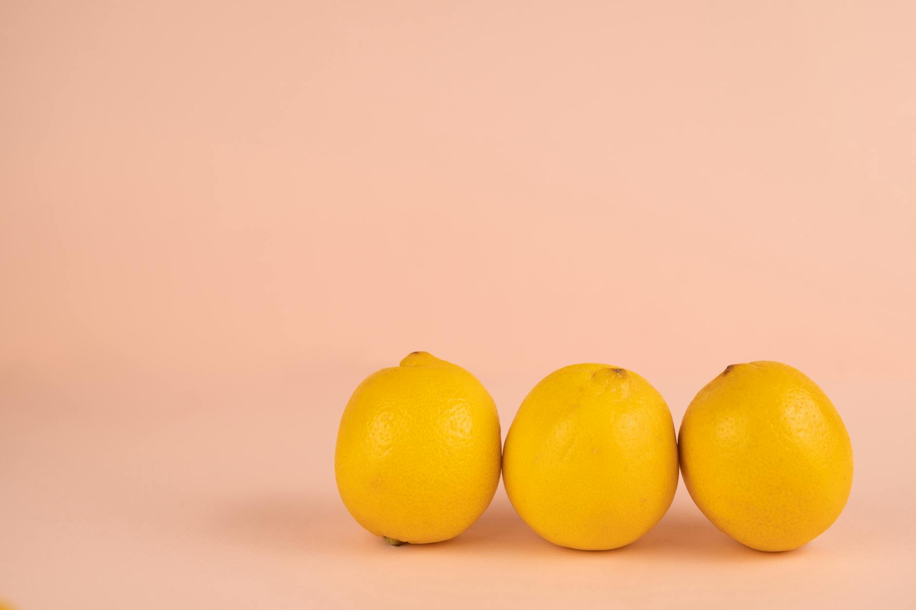 Bright yellow lemons on a vivid yellow background in studio lighting