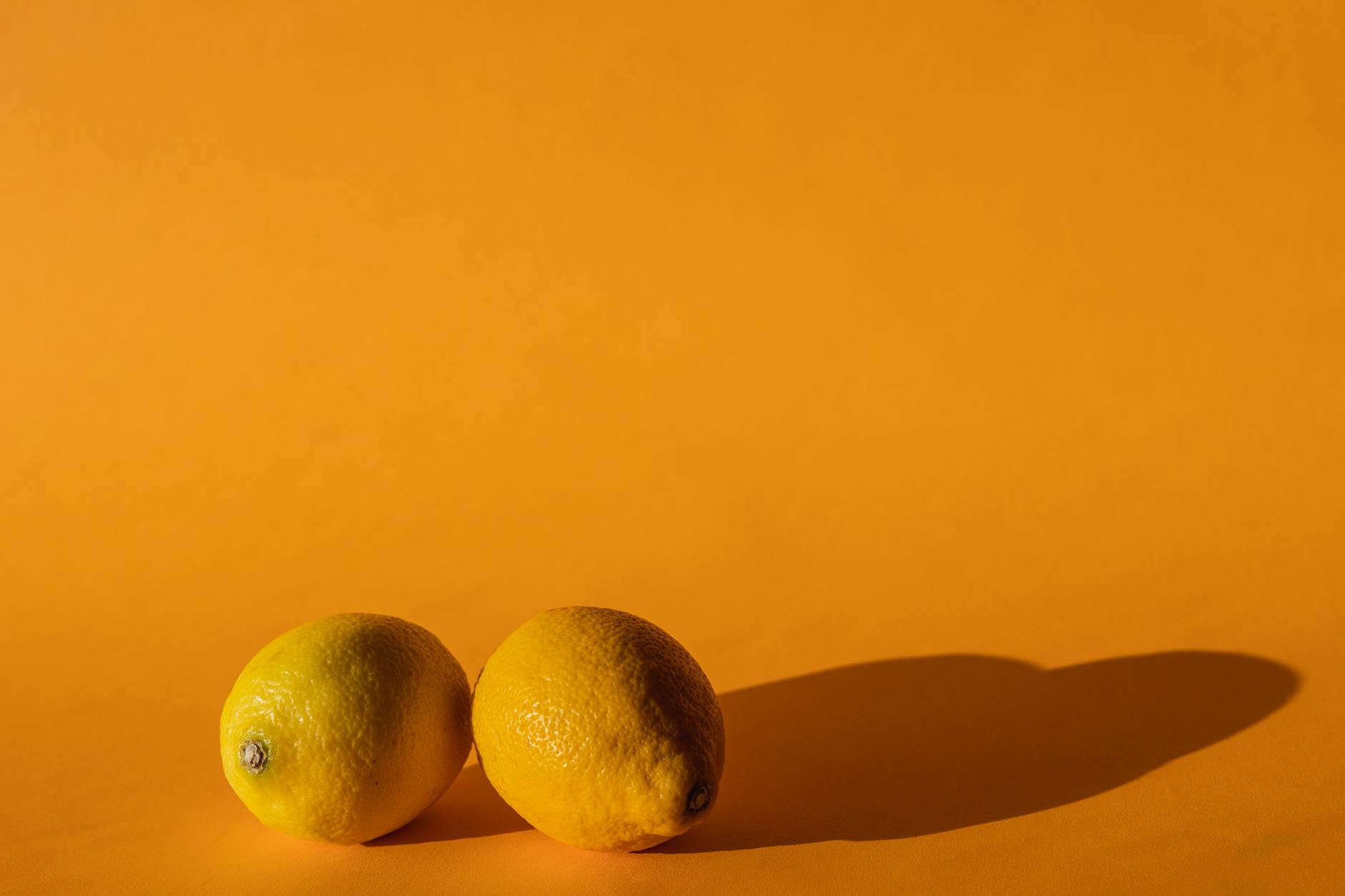 Fresh lemons on a bright yellow background, symbolizing sensitivity shifts and sensory change
